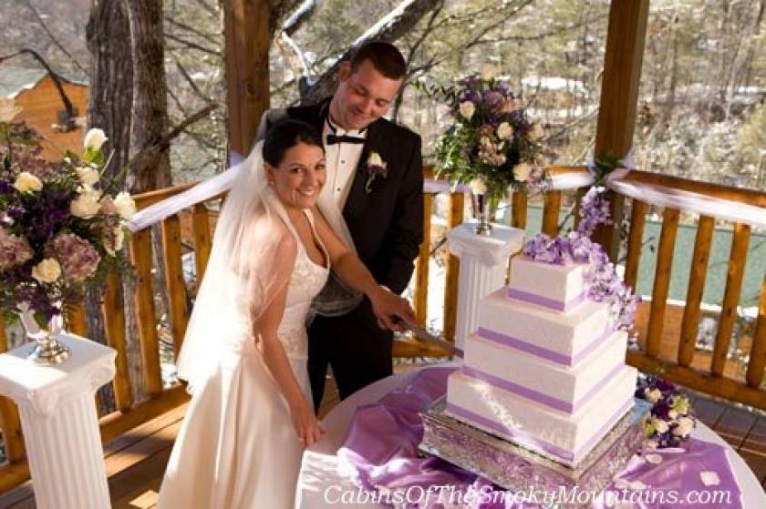 Couple cutting wedding cake.