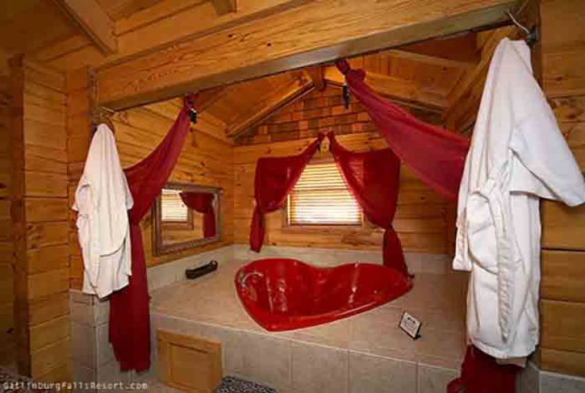 Heart shaped tub with two robes.